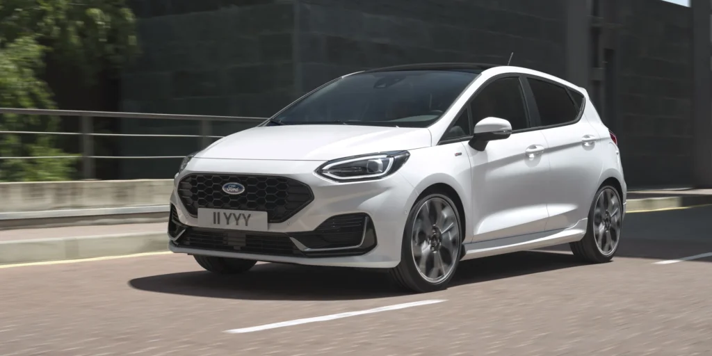 White Ford Fiesta car driving on a highway.